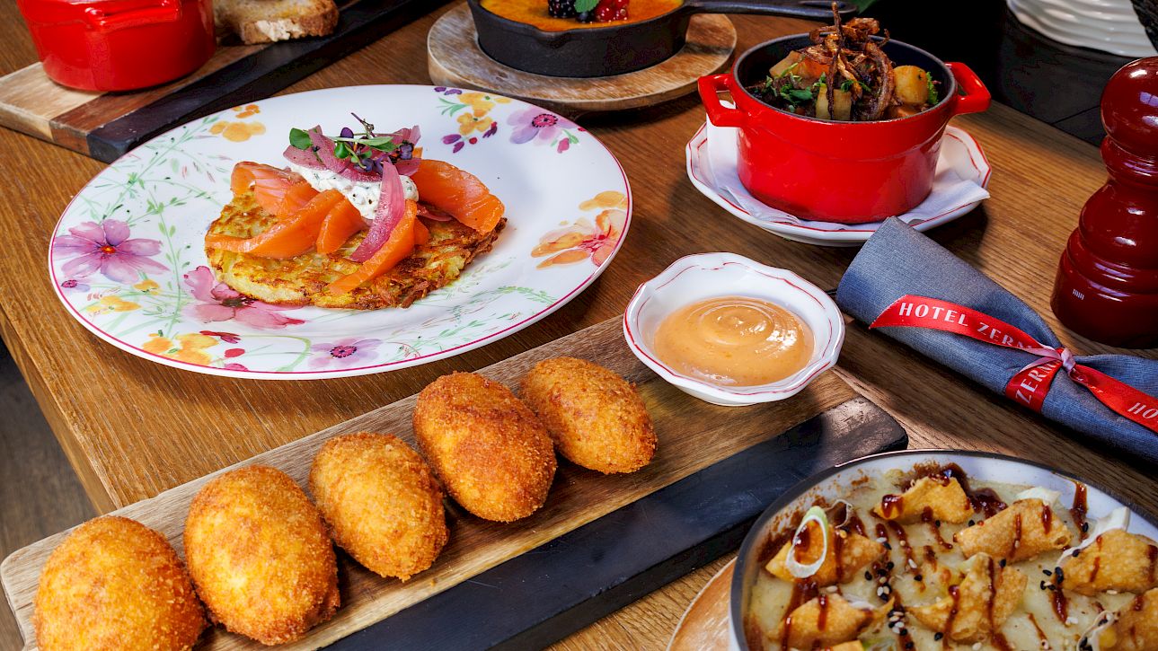 Various delicious dishes on a table, including croquettes, salmon, and sides.