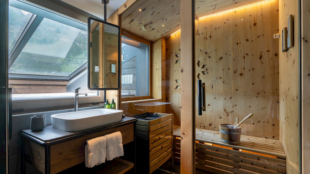 Modern bathroom with sink, mirror, and wooden sauna, illuminated by skylight.