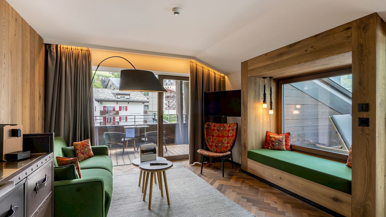 Modern living room with wooden accents, green sofa, and large window leading to a balcony.