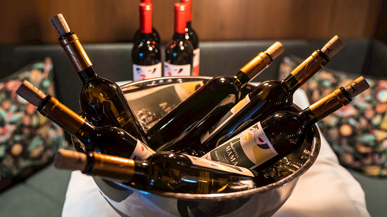 Un bol élégant rempli de bouteilles de vin, entouré de plus de bouteilles sur un fond chic.