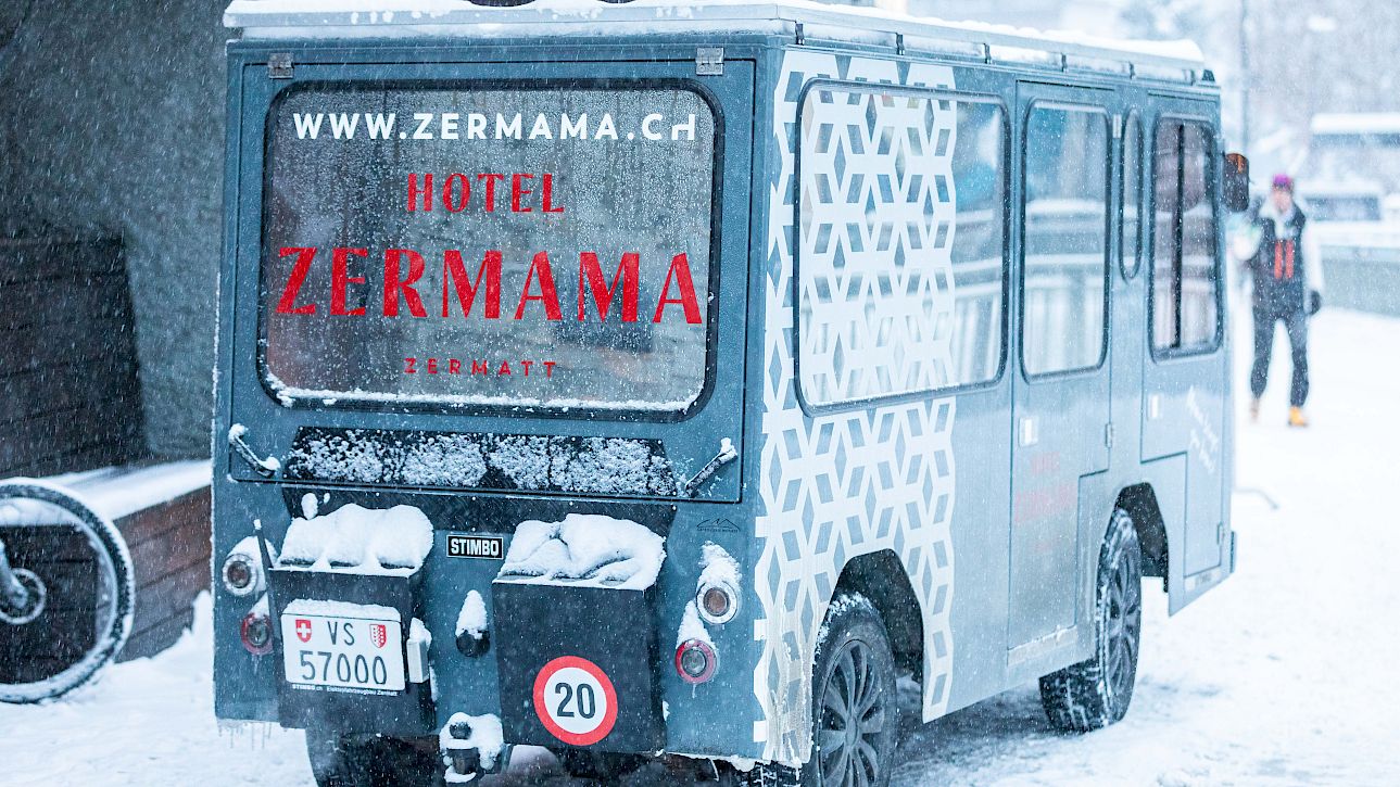Small hotel bus for Zermama in the snow, Zermatt. Vehicle with unique geometric pattern.