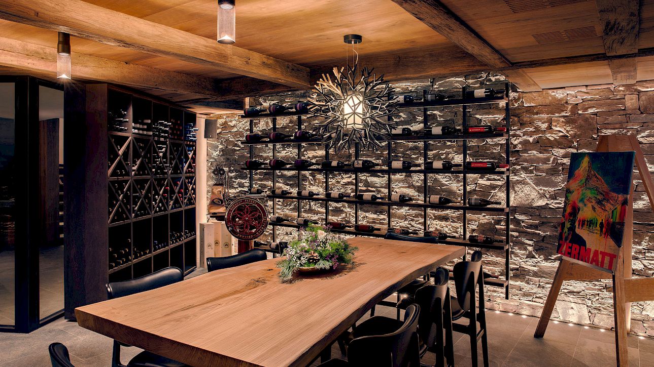 Gemütlicher Weinkeller mit Holztisch, dekorativer Wand und moderner Beleuchtung, ideal für Weinproben.
